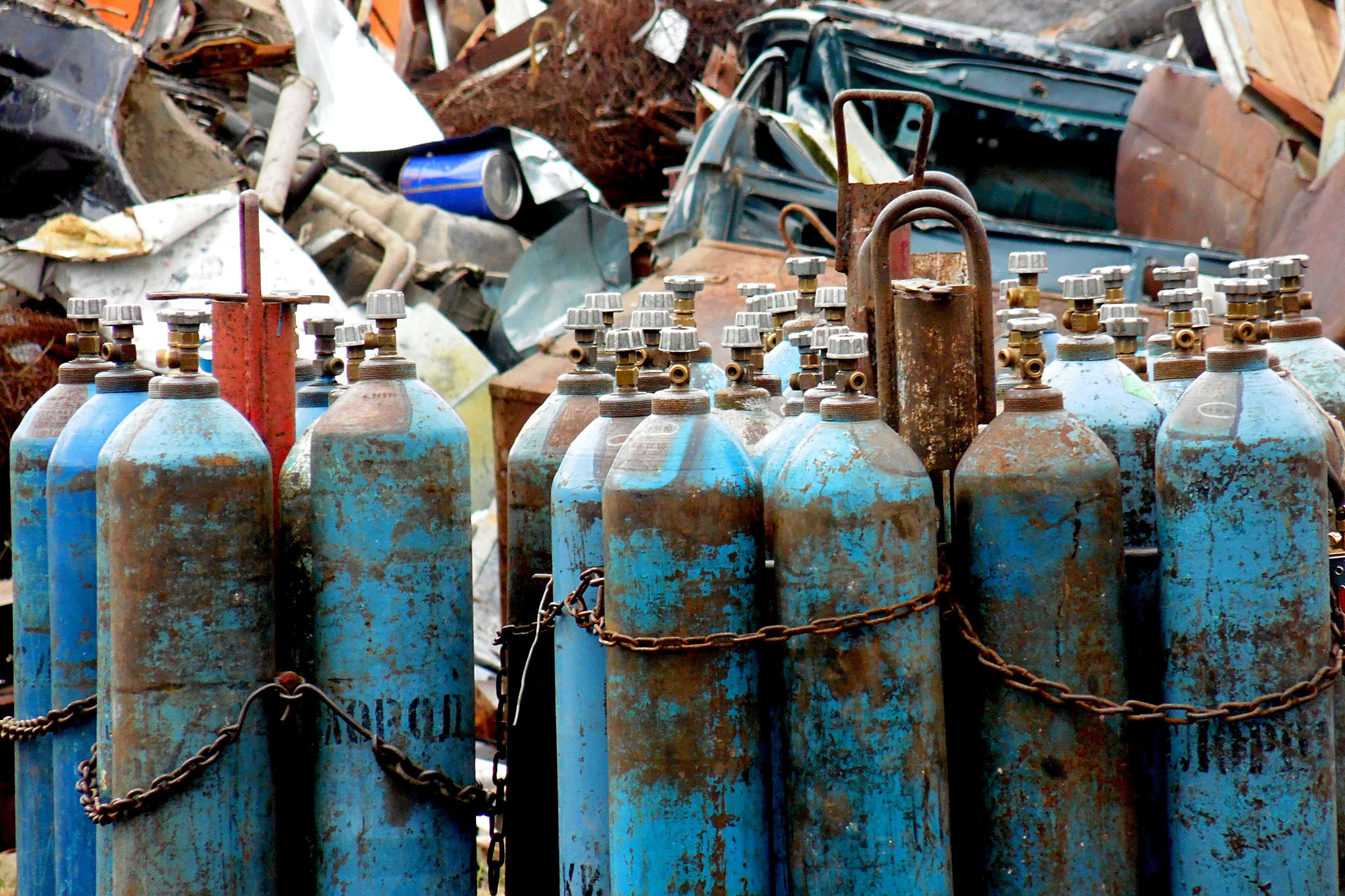 Gas cylinders stored upright with regulators capped, representing high-purity lab gas supply.