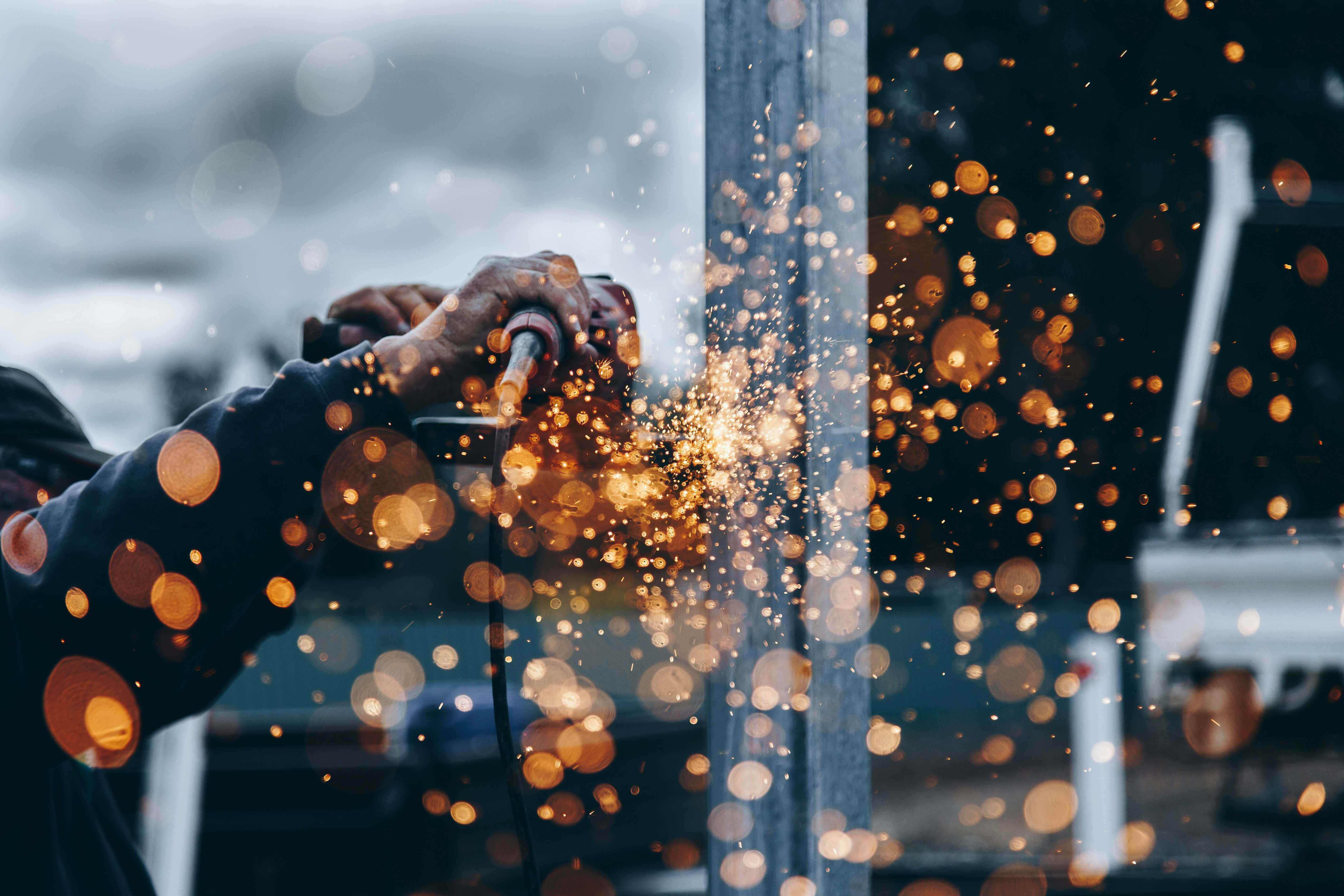 Close-up of hands holding a welding torch, preparing for steel welding work